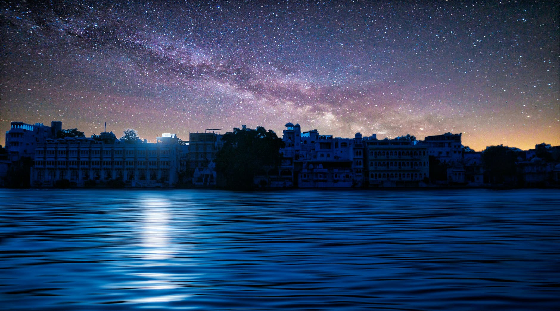 city near body of water under a starry sky